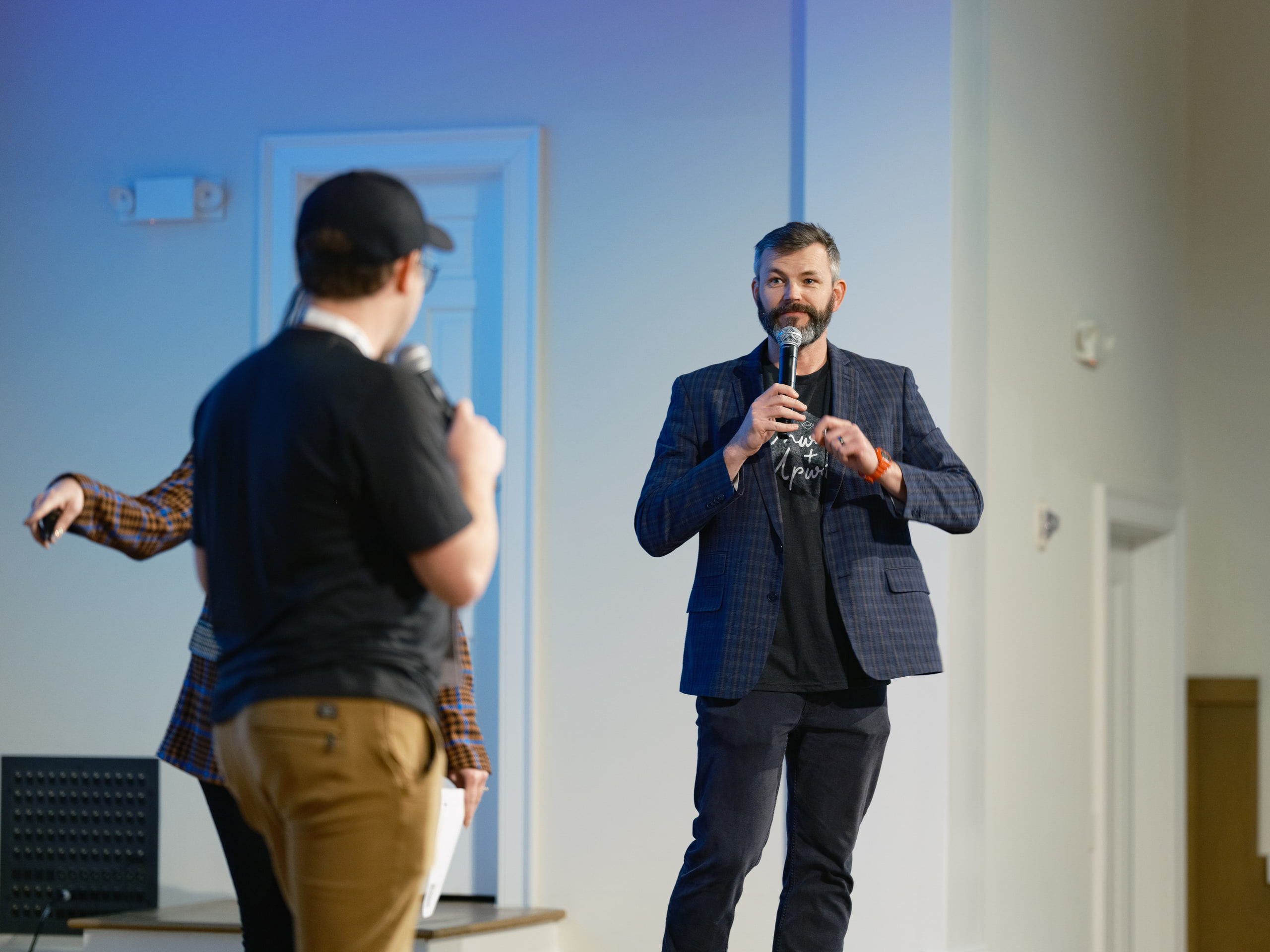 Speaker with the mic, blue jacket, portrait at a conference in Nashville.