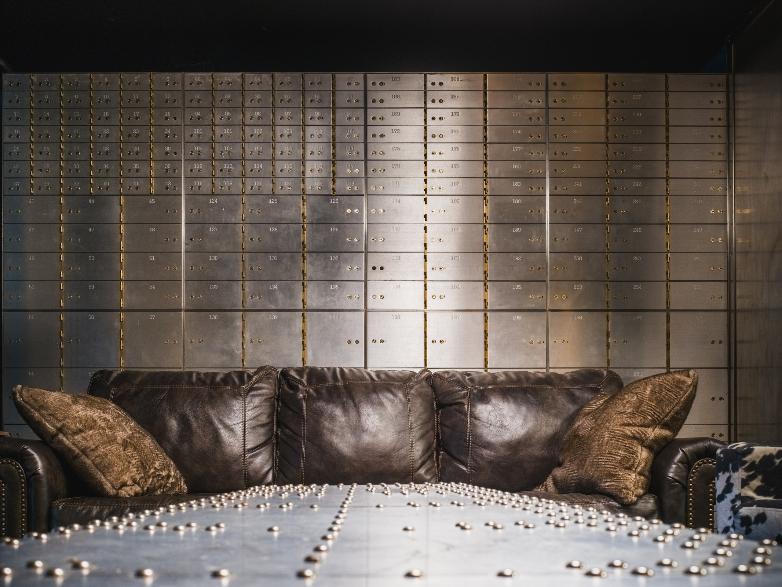 A leather sofa against the wall of safe-deposit boxes at The Exchange on Loudoun.