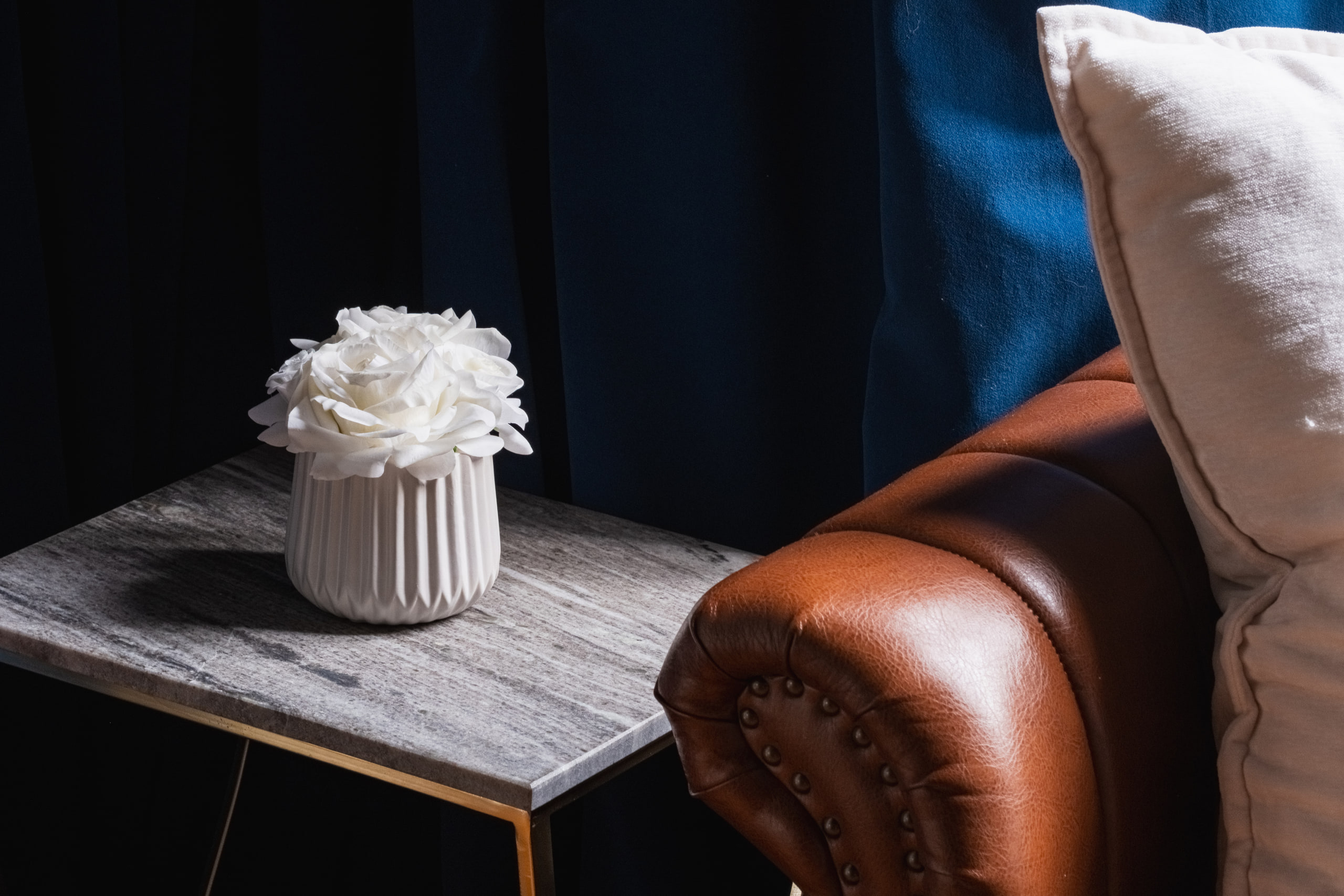 Flowers on the side table, leather chair, detail.