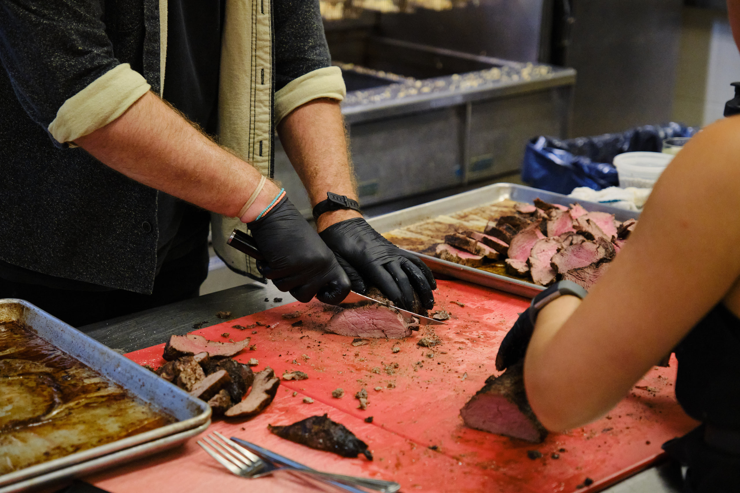 Gloved hands slicing, close, tactile.