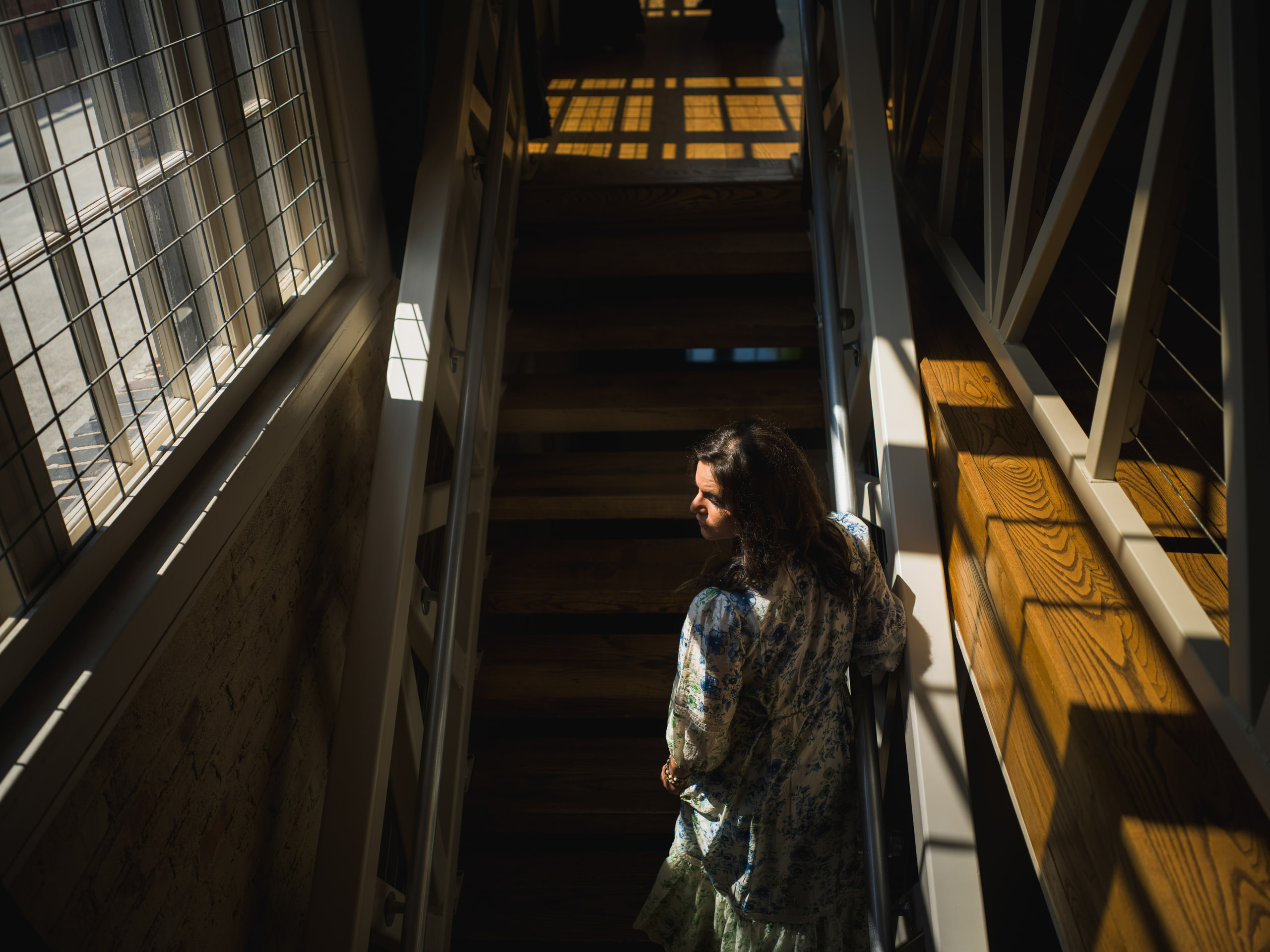 A musician on the industrial stair at The Exchange on Loudoun, looking up.