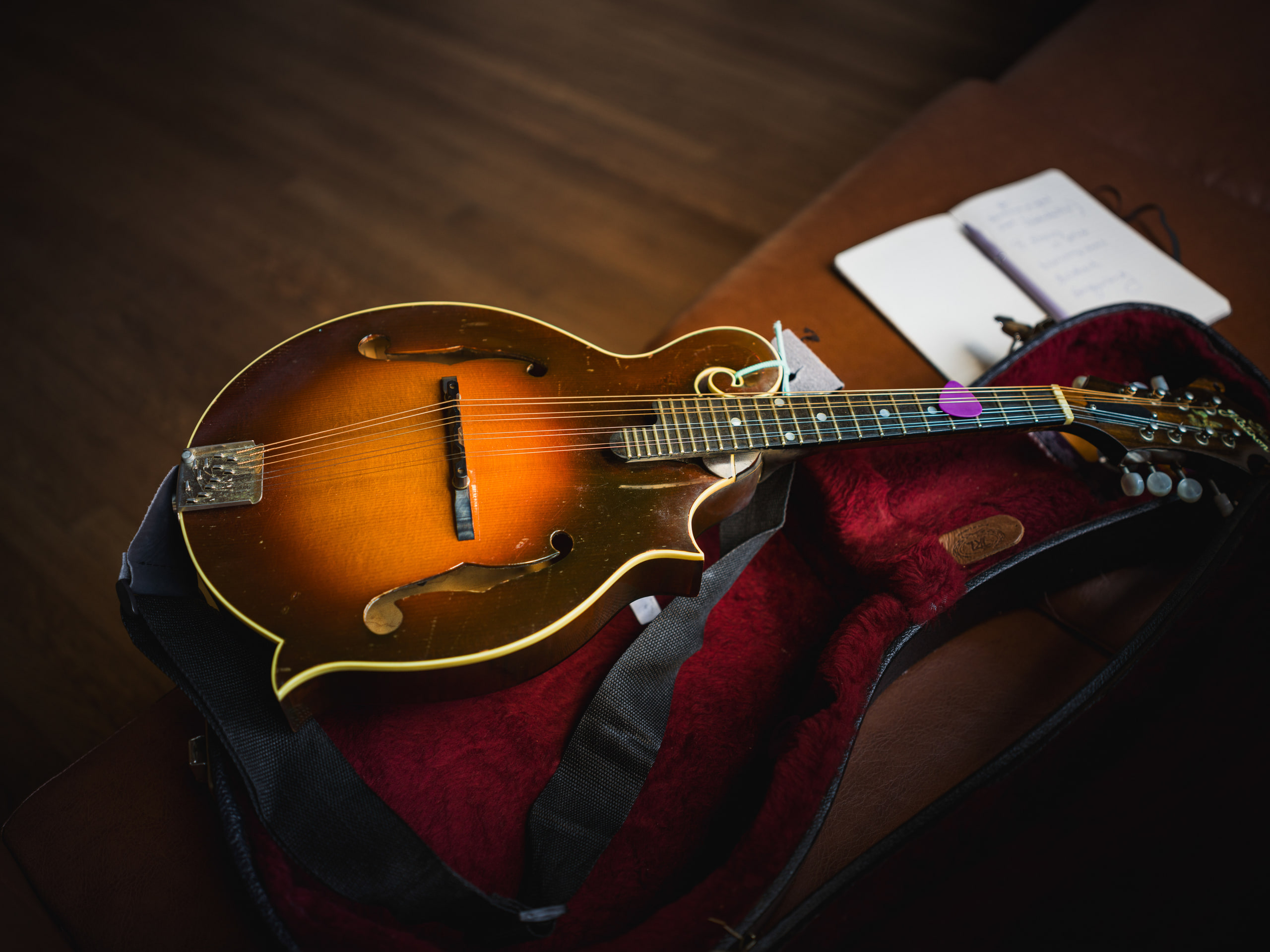 A mandolin and a notebook on a table, detail.