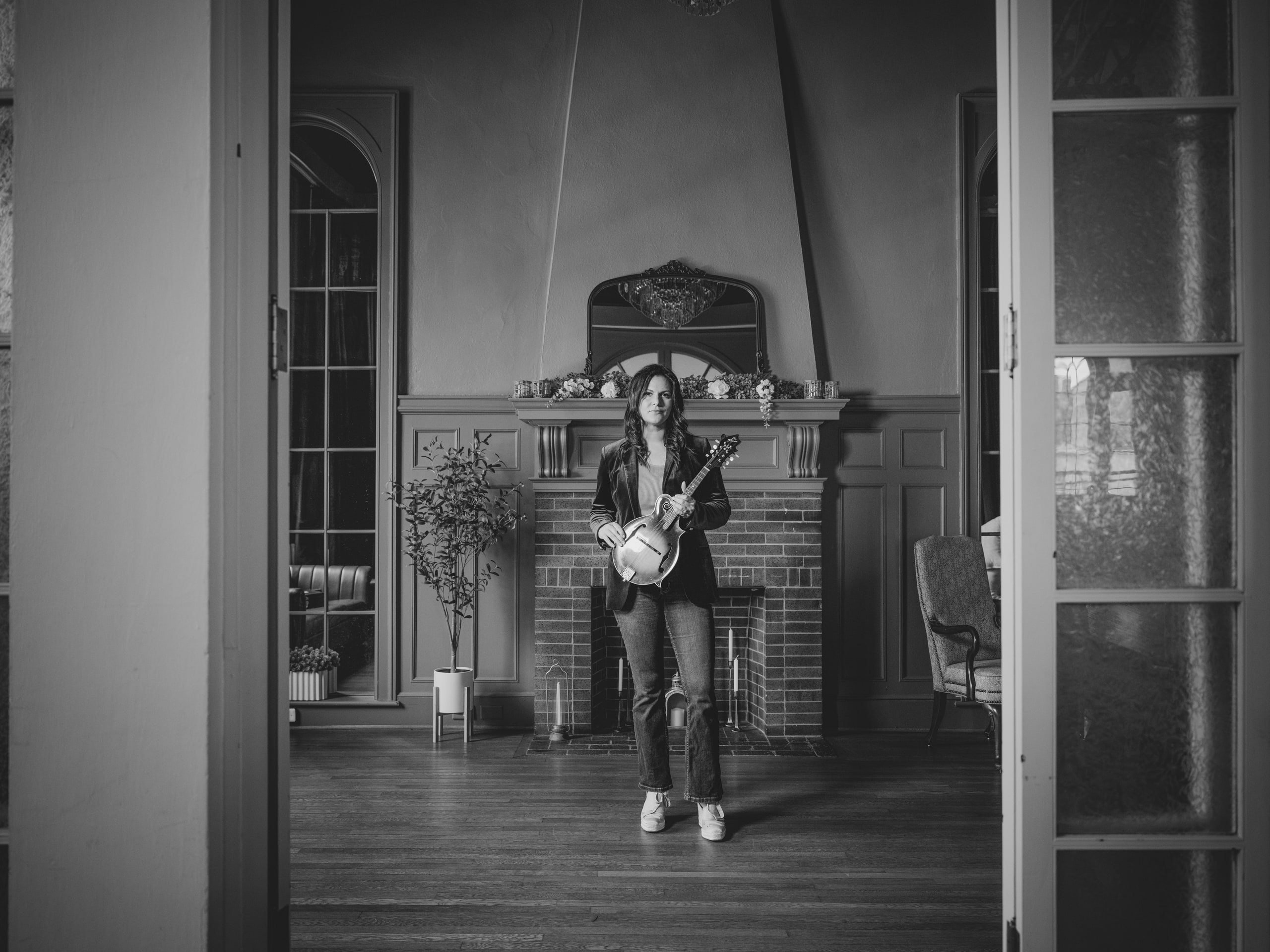 A musician with a mandolin in the fireplace lounge at The Exchange on Loudoun, black and white.