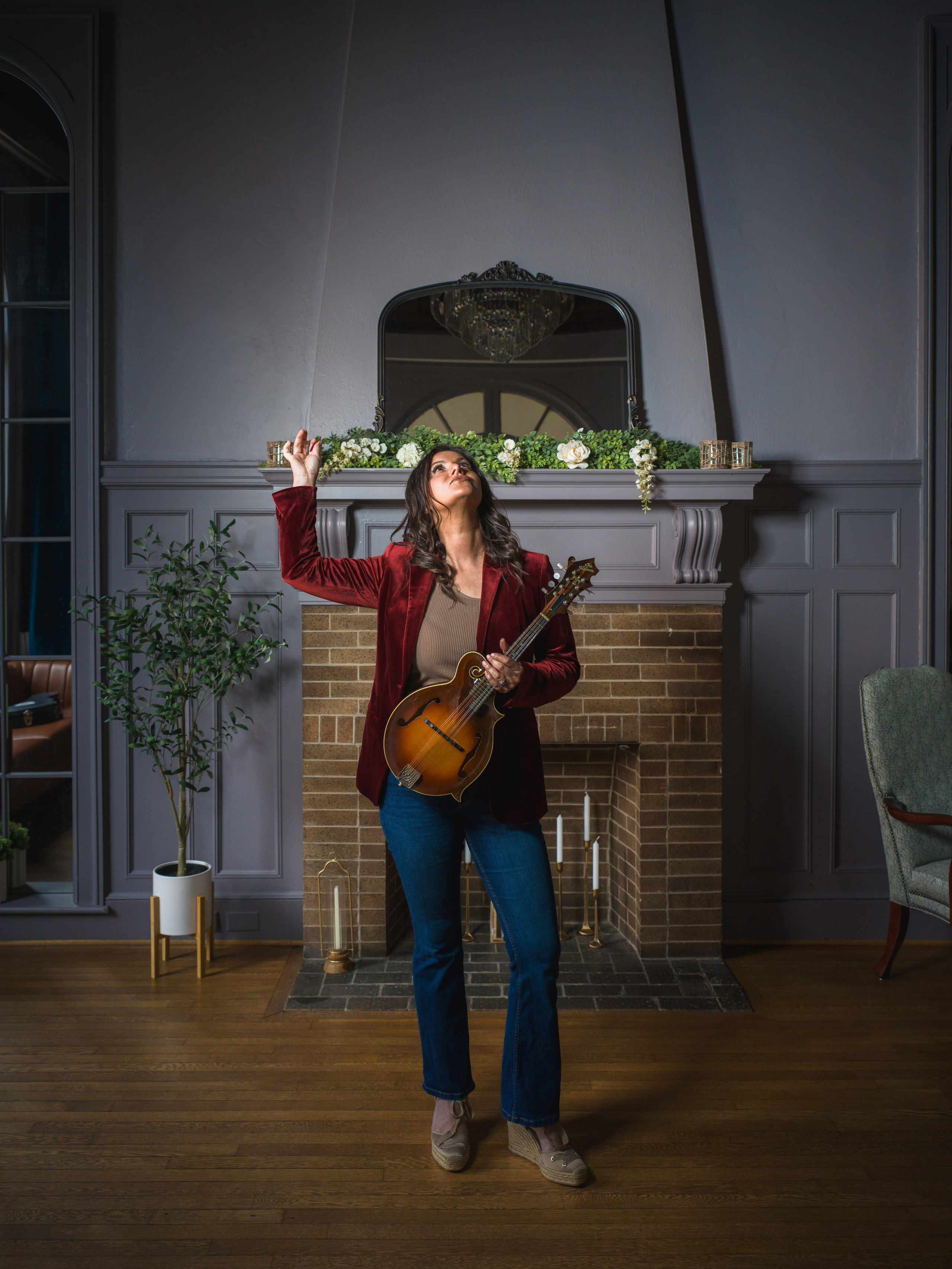 A musician in the fireplace lounge at The Exchange on Loudoun, one arm raised.
