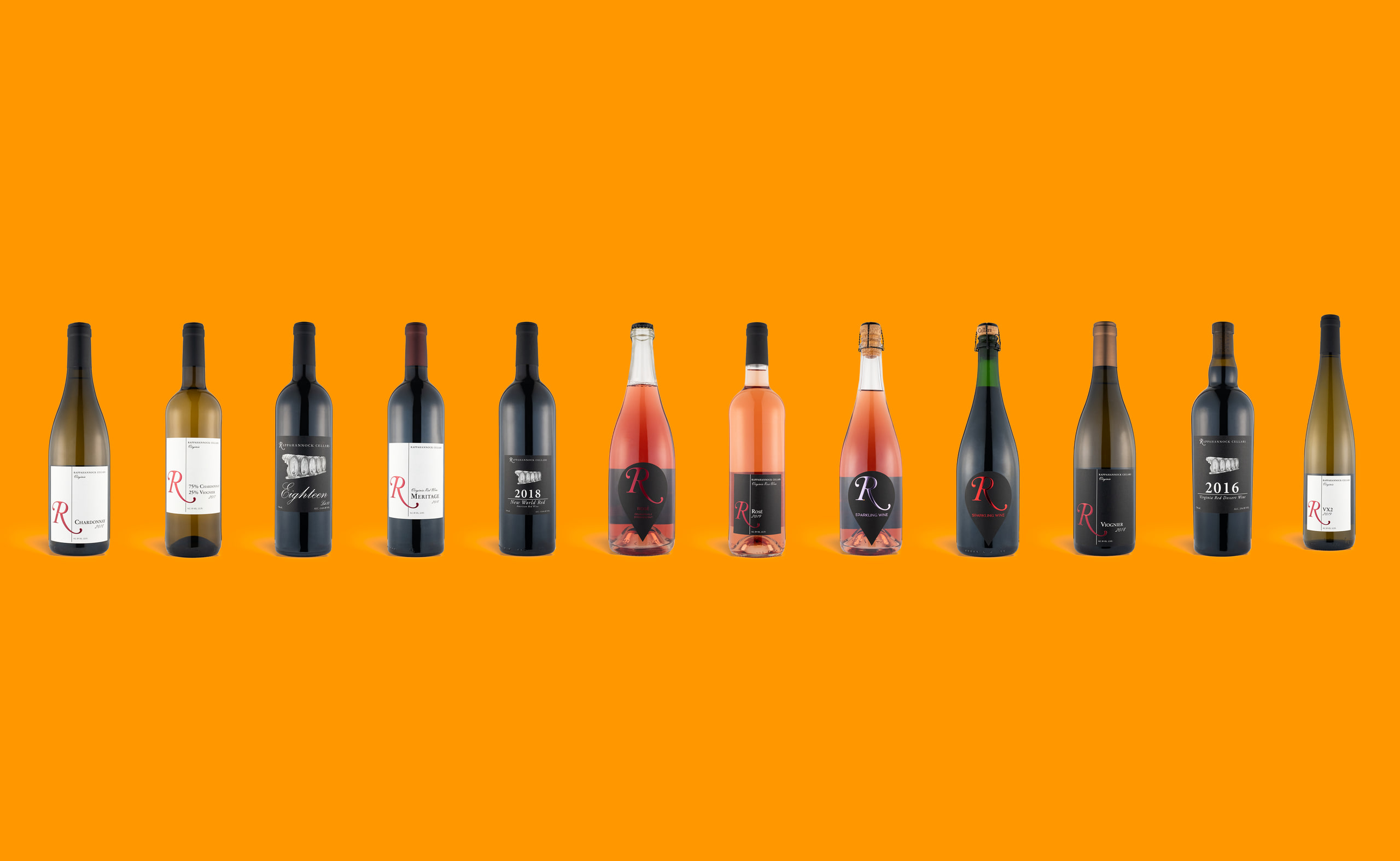 Bottle row on orange, pure color field.