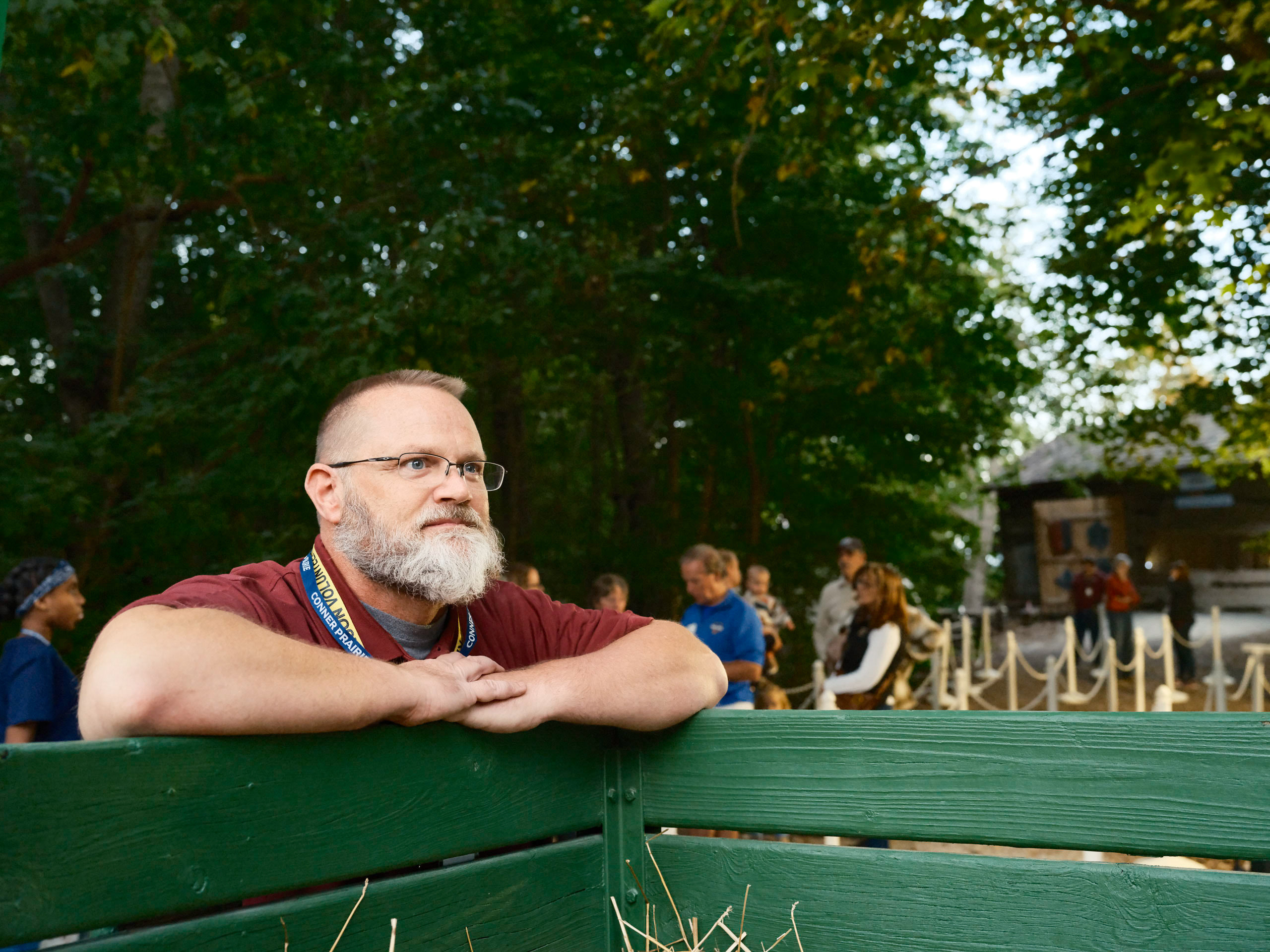 Man leaning on the rail, warm, portrait at a community event.