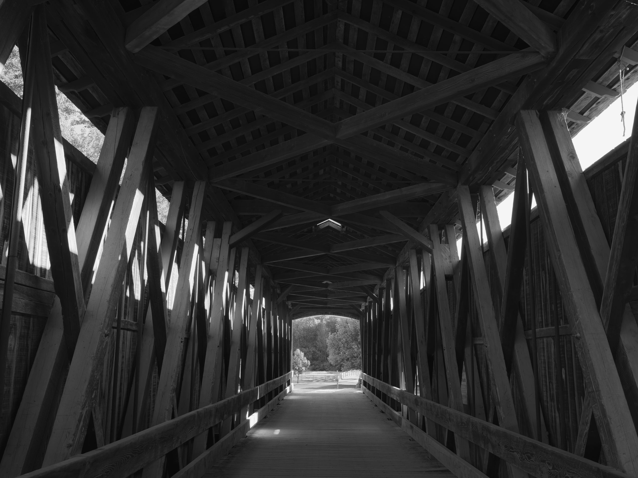 B&w covered bridge interior, one-point perspective.