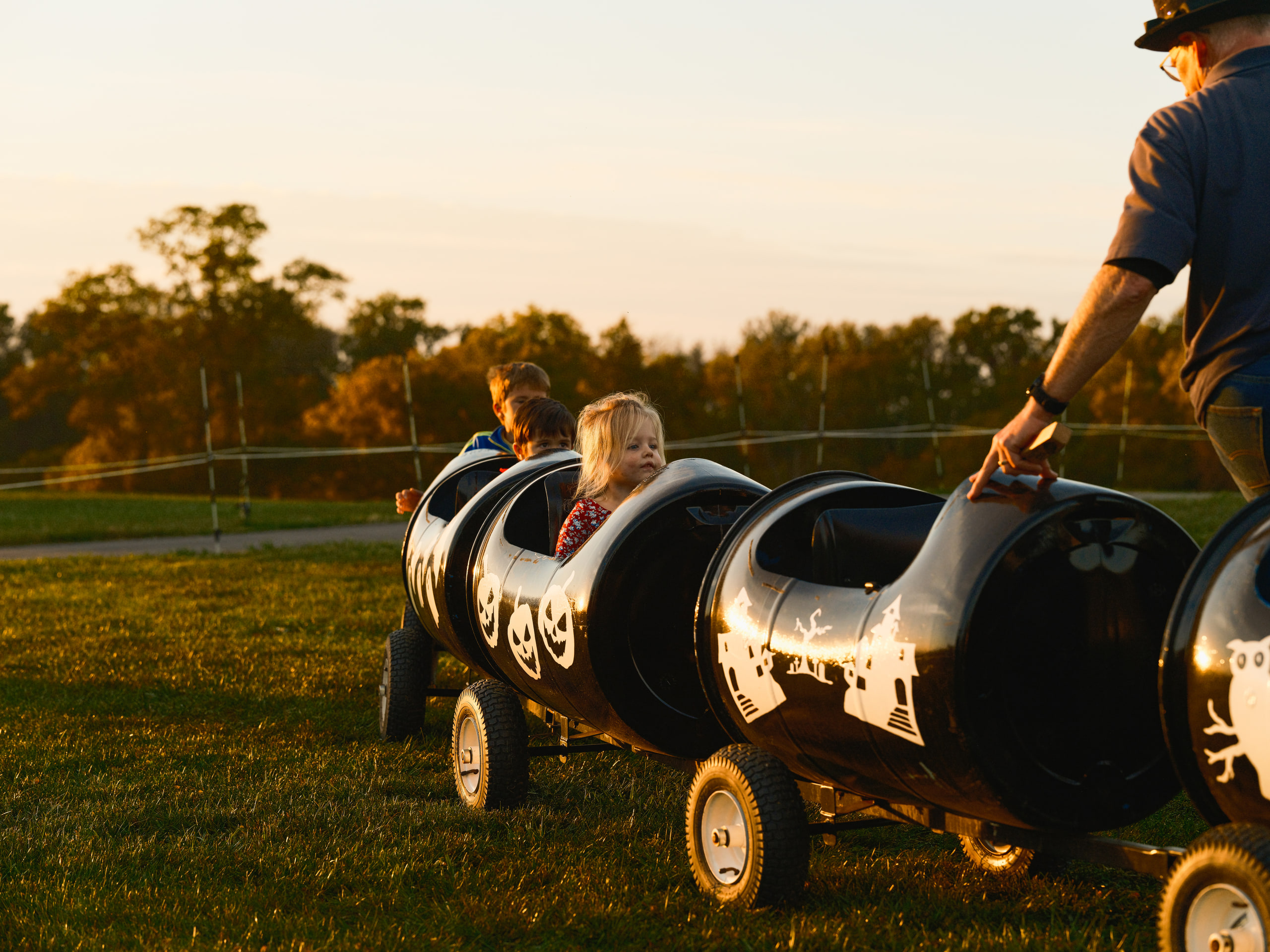 Tractor at dusk, warm light, people around it.