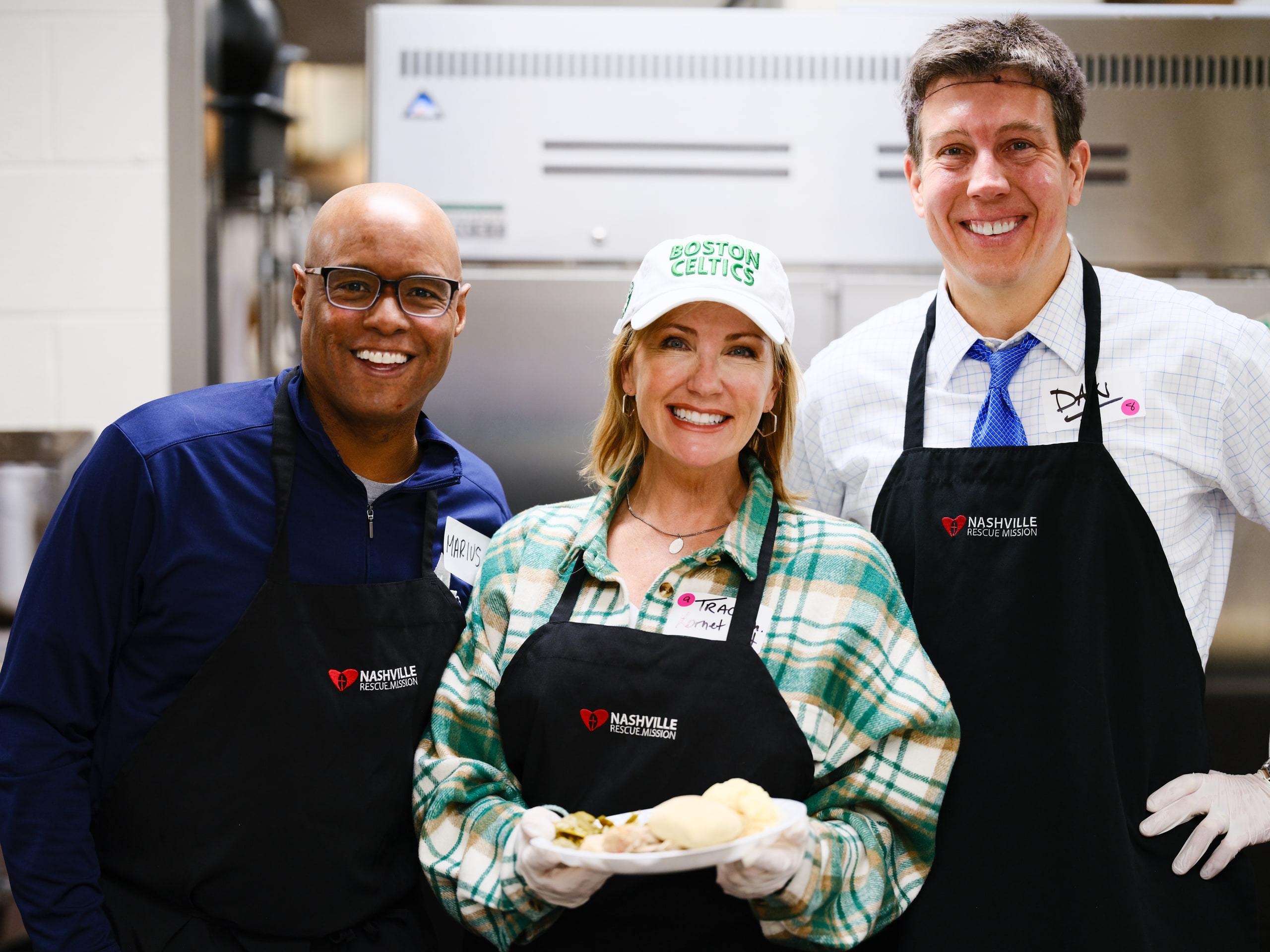 Three in aprons, smiling at a community event.