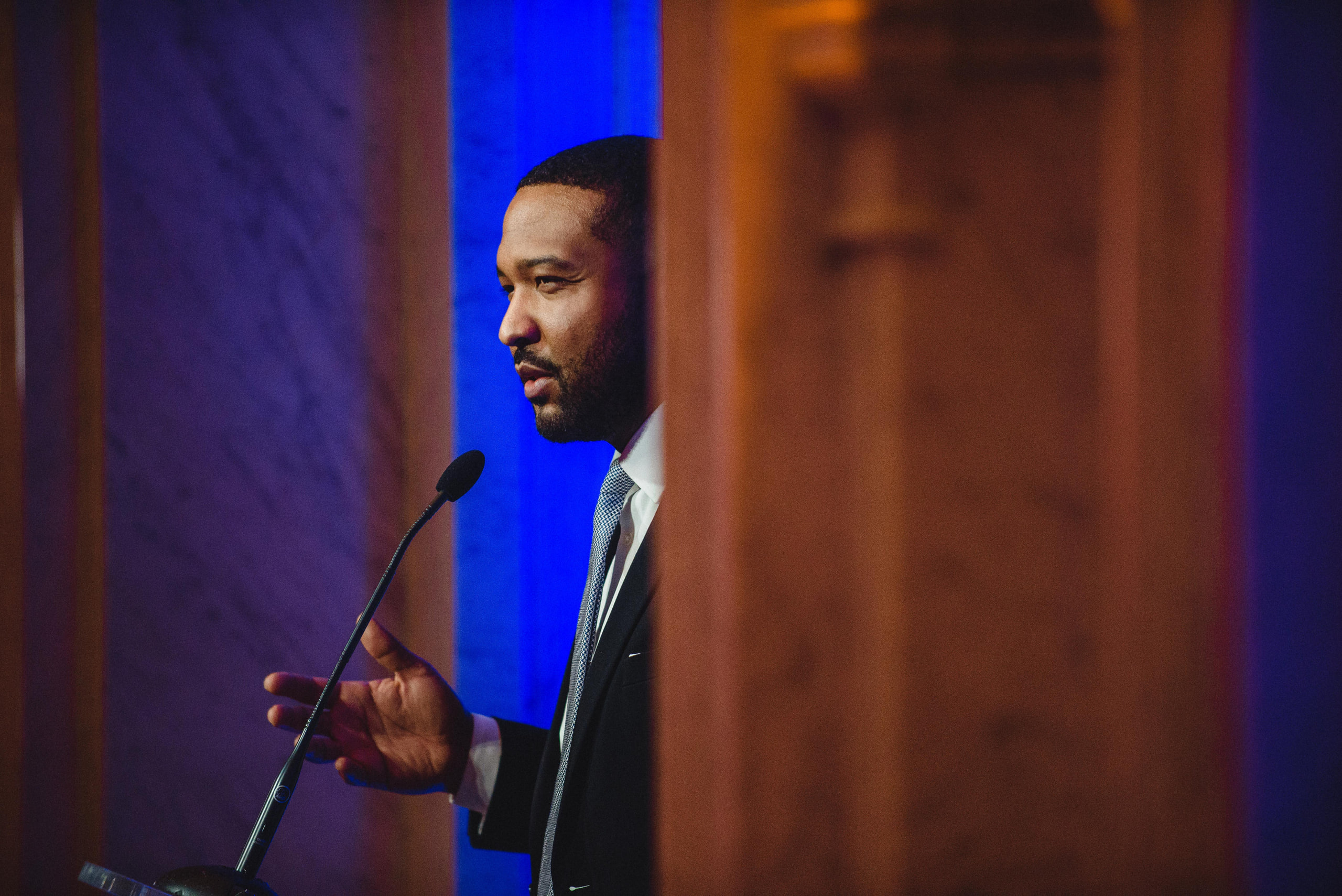 Speaker mid-gesture, blue, portrait at a conference in Washington, DC.