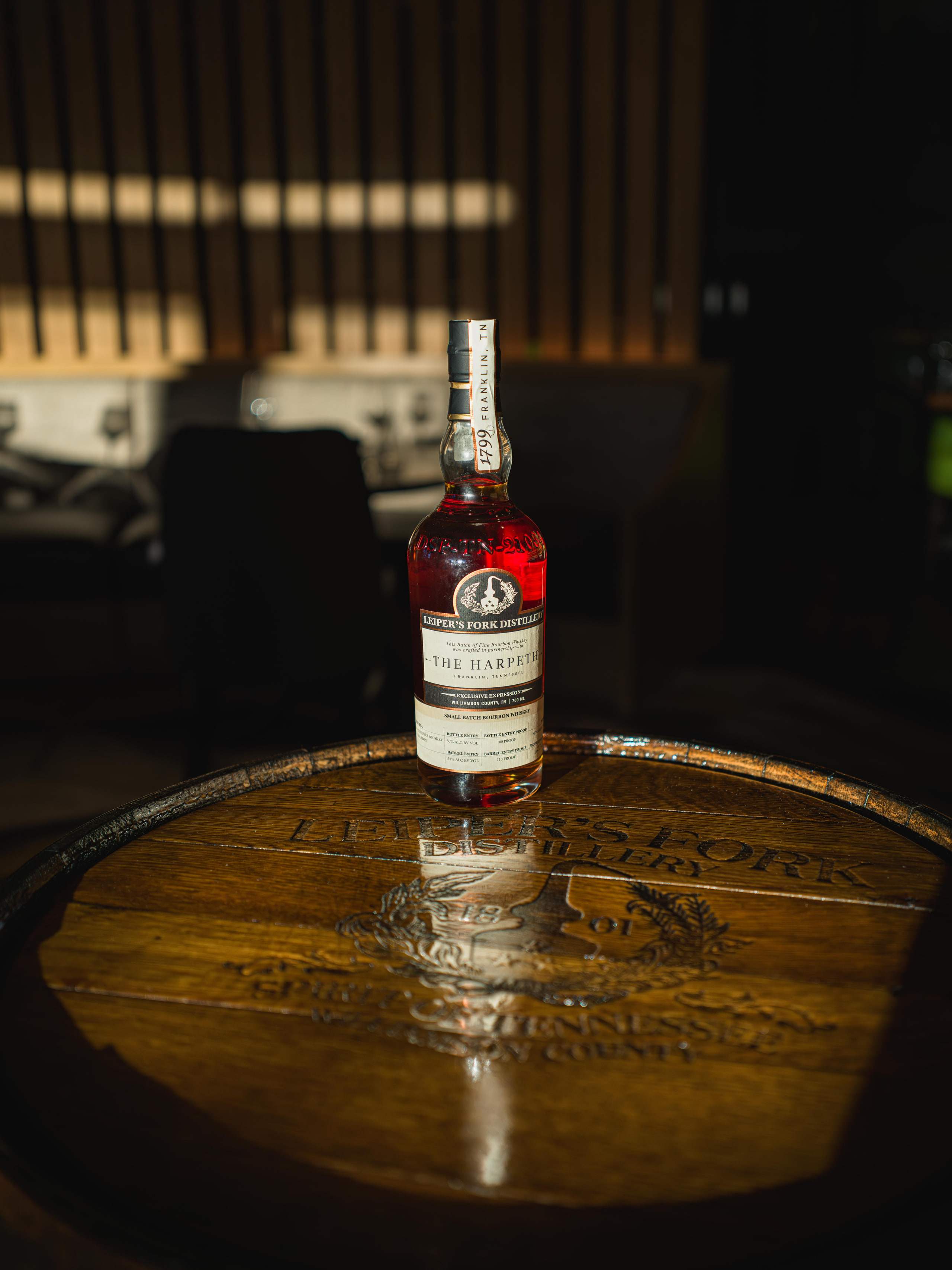 One bottle on a barrel in the dark.