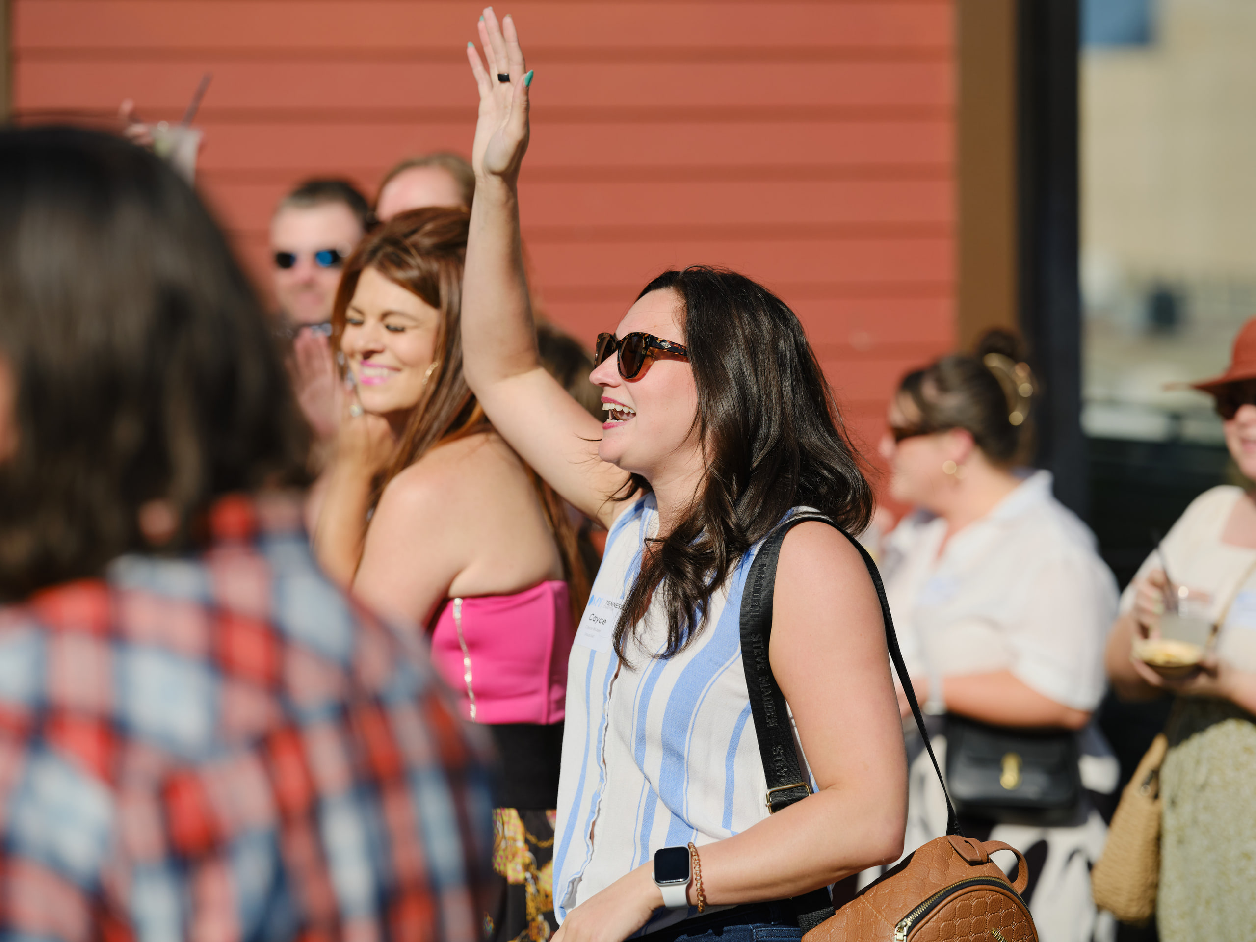 Arm up in the crowd, rooftop, color at a rooftop industry mixer, Nashville.