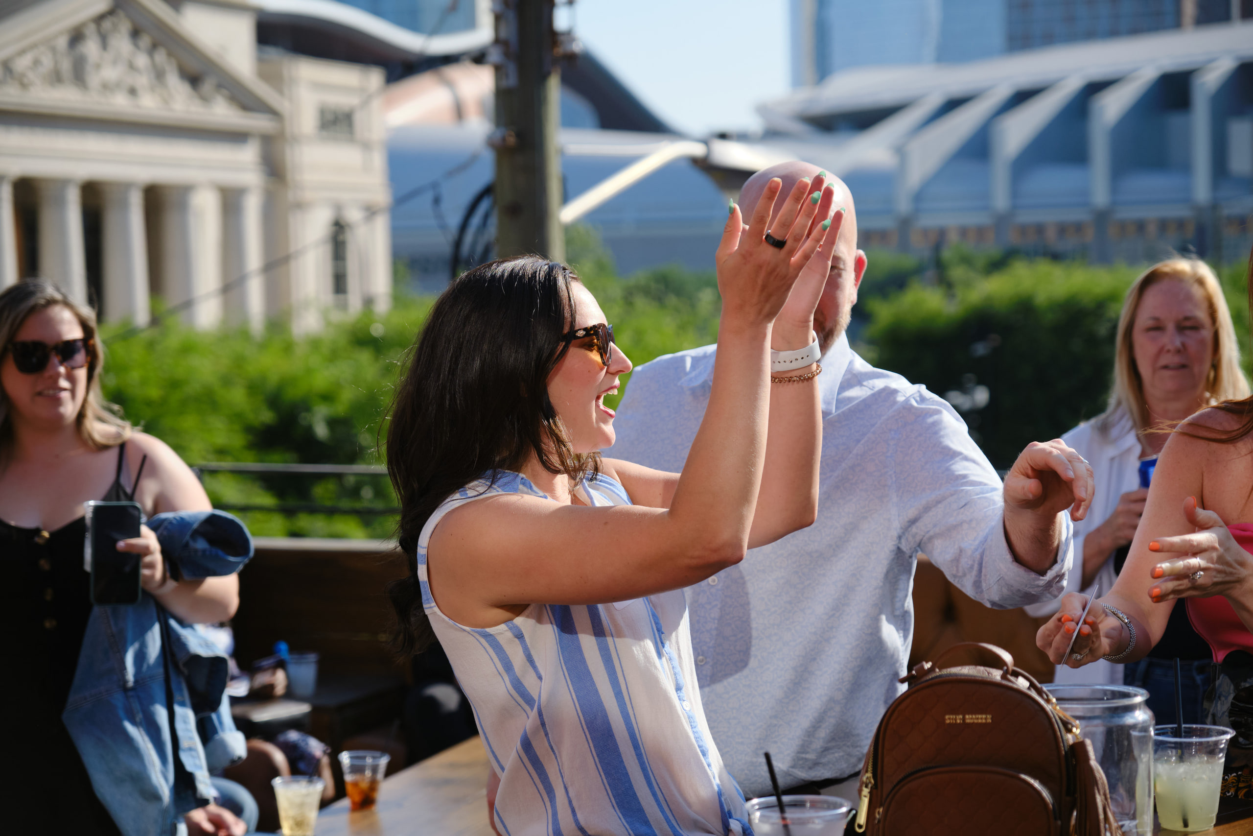 Hands clasped mid-laugh, Nashville rooftop at a rooftop industry mixer, Nashville.