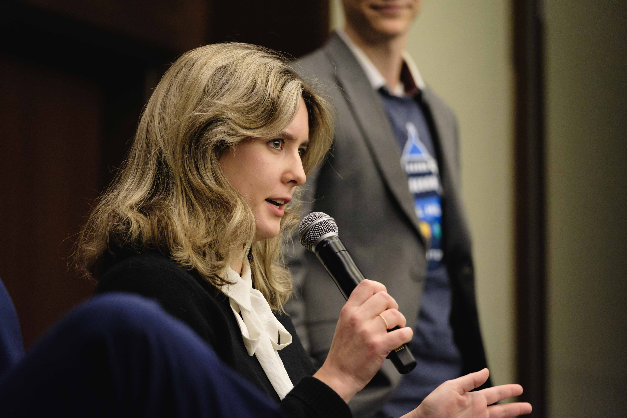Panelist with mic, blond at a Capitol Hill day kickoff.
