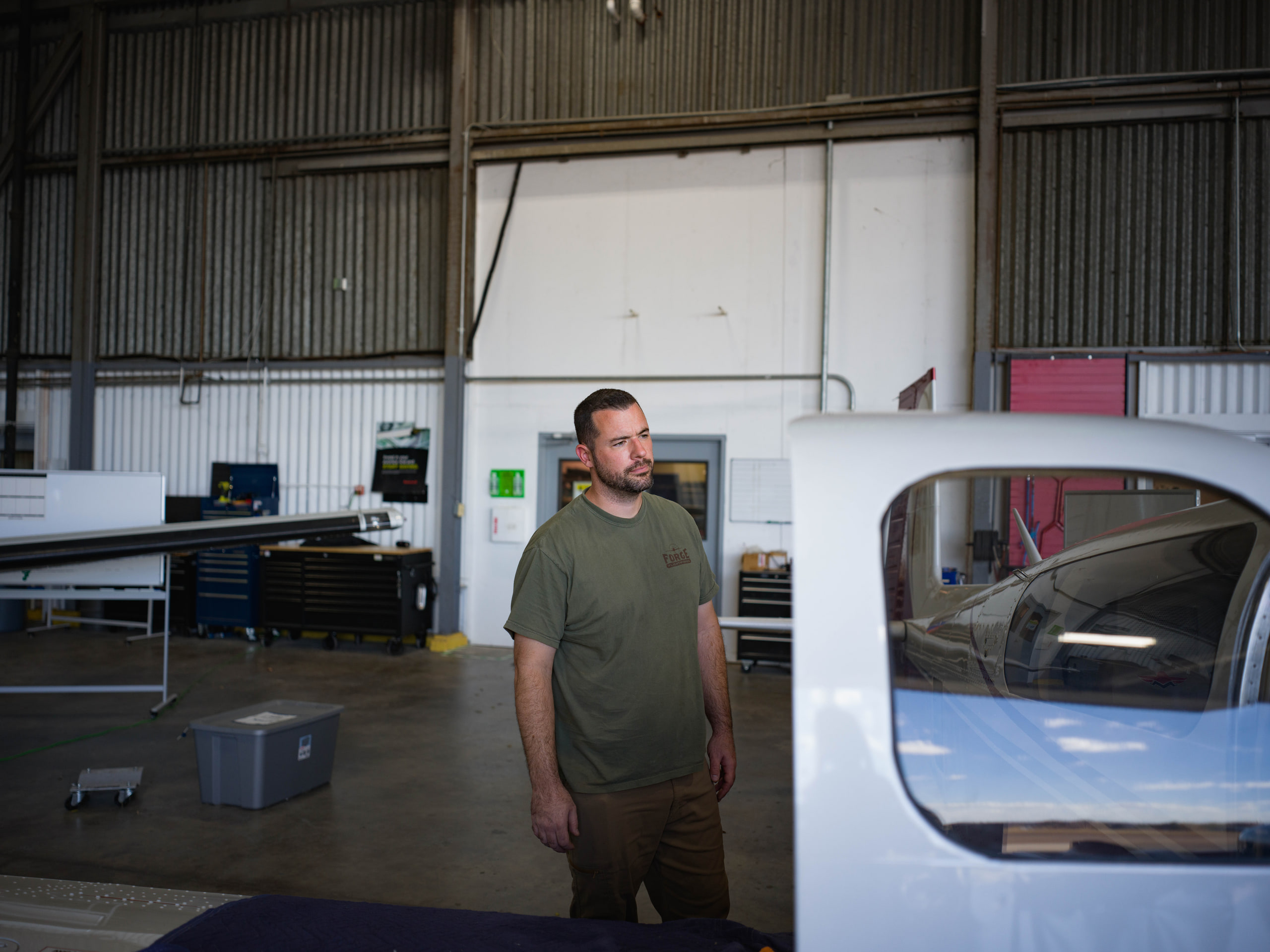 Mechanic standing at the tail, the hangar at an aviation maintenance company.