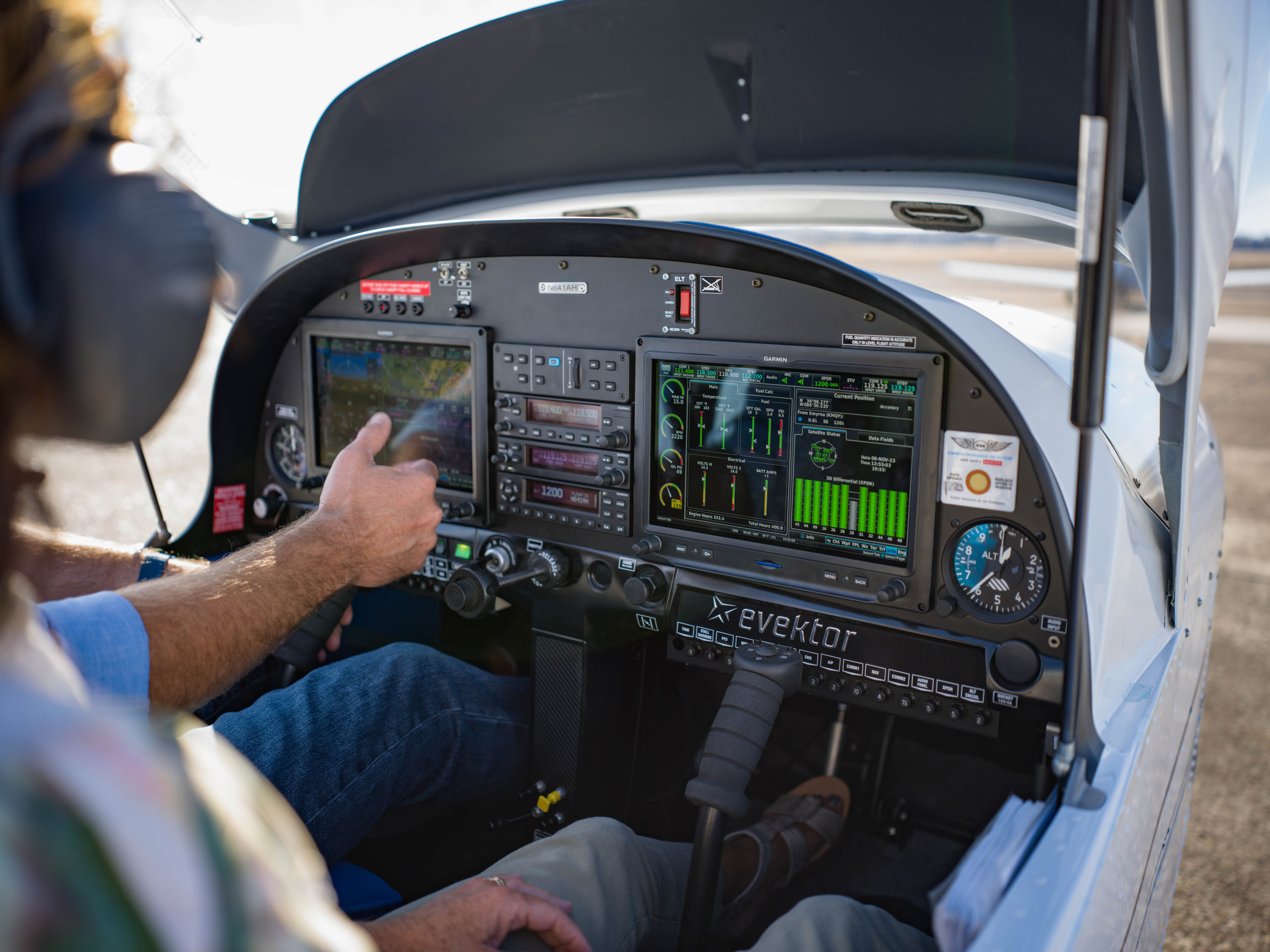 Hand on the panel from the back seat, headset, color at an aviation maintenance company.