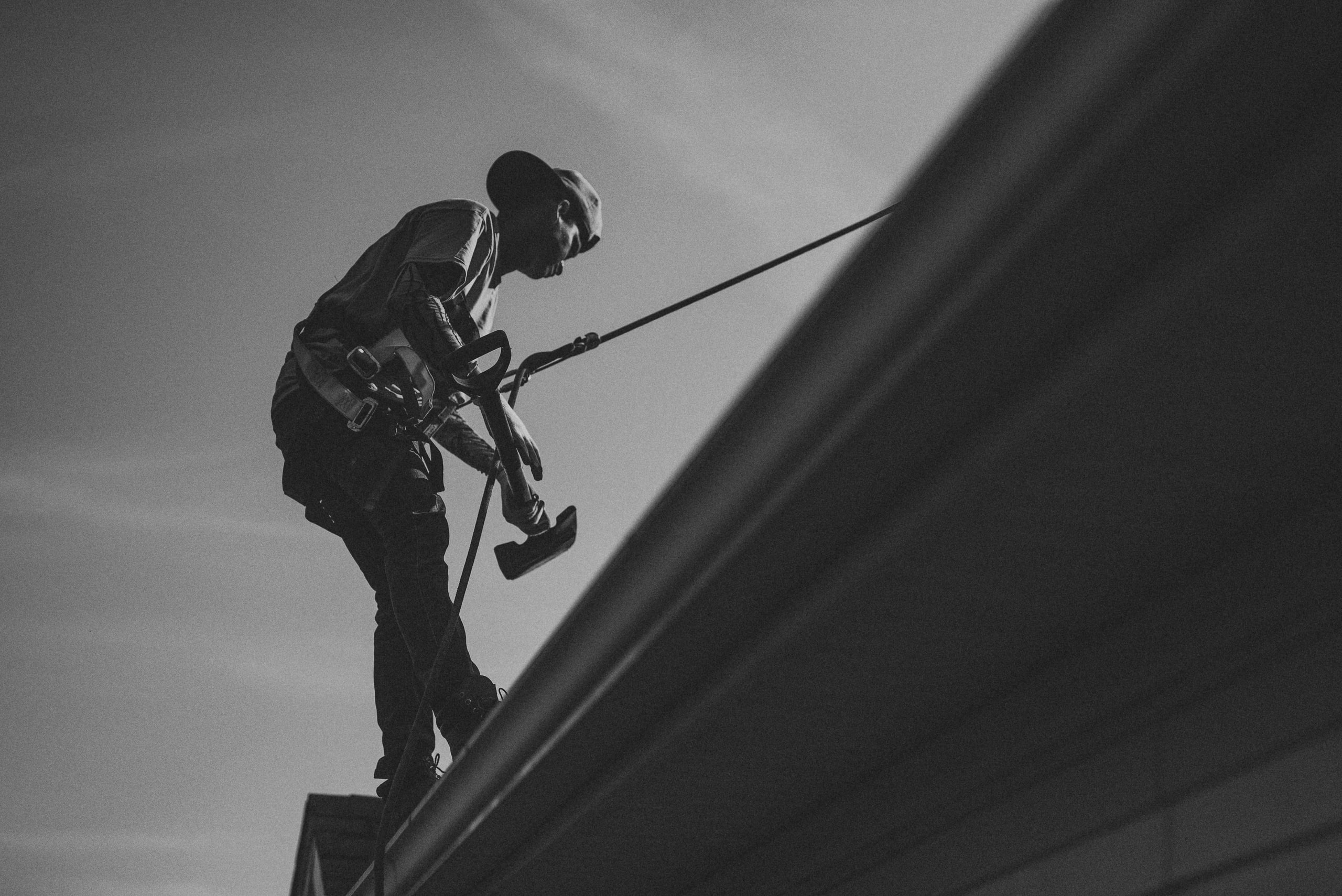 B&w worker on a tower, scale and nerve.