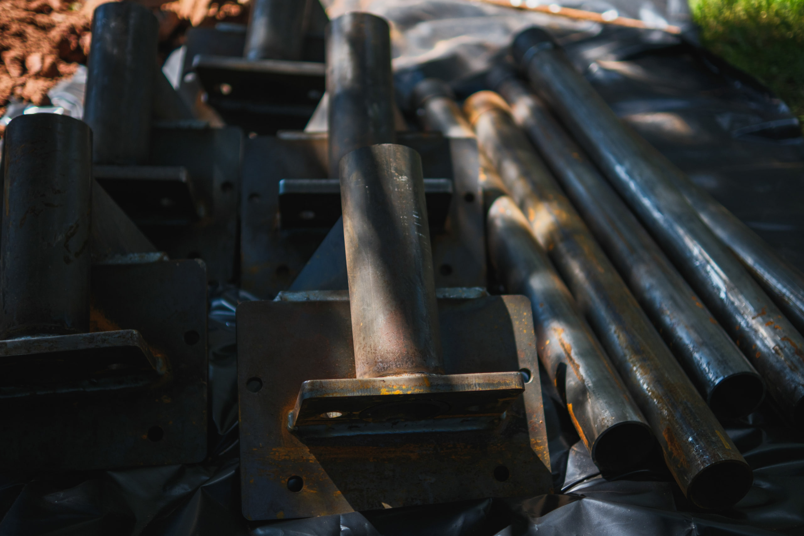 Stacked steel pier sections in raking light — the graphic frame from the same job. Approved alongside, for the band.