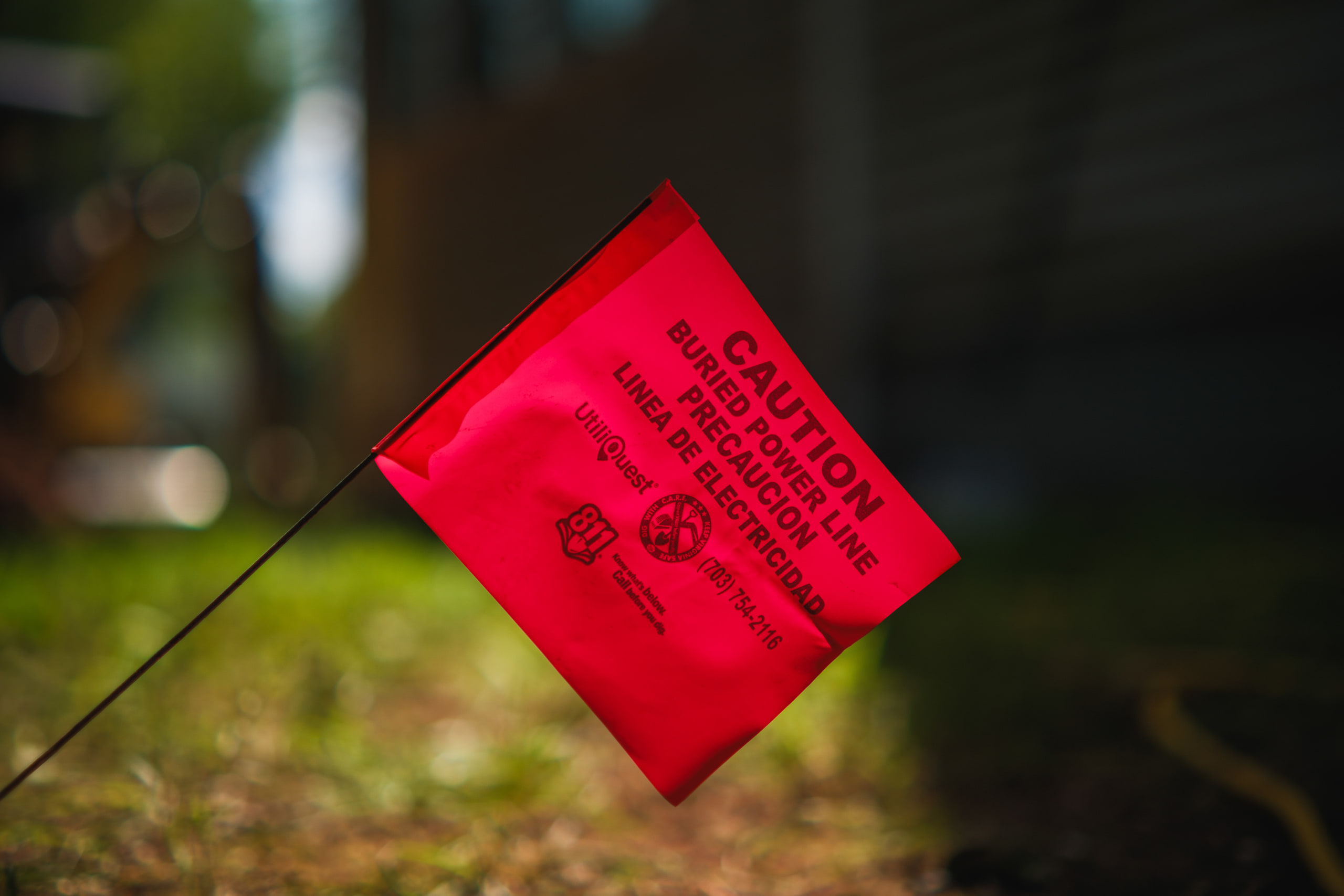 A red caution flag in the grass, in shallow focus.