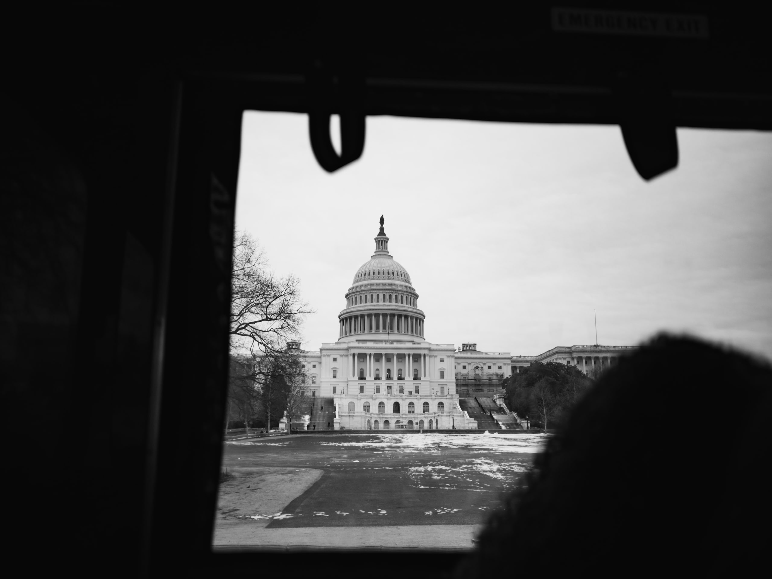 Capitol through the trolley window, black and white framing at a Capitol Hill day in Washington, DC.