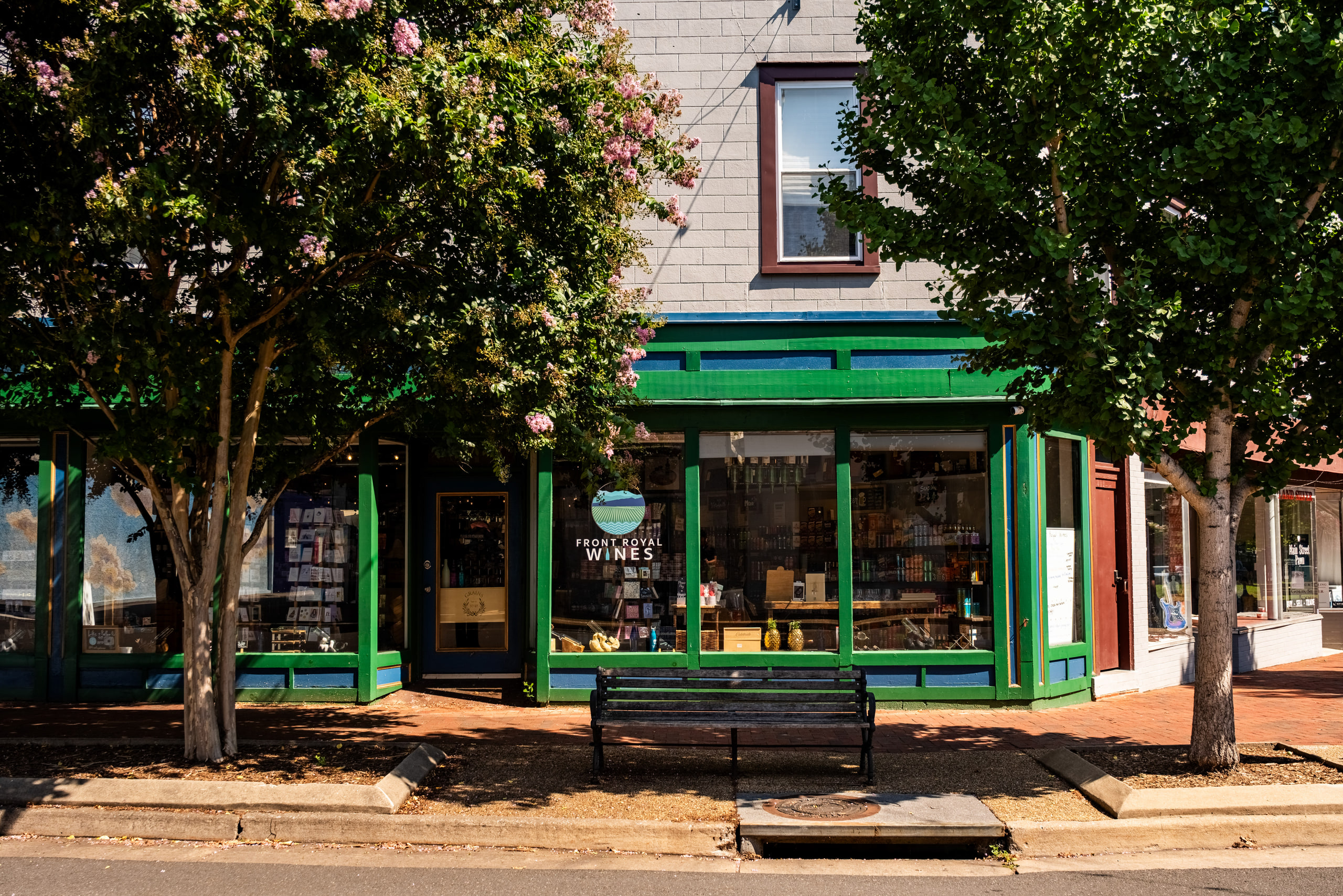 Storefront through trees, street context.