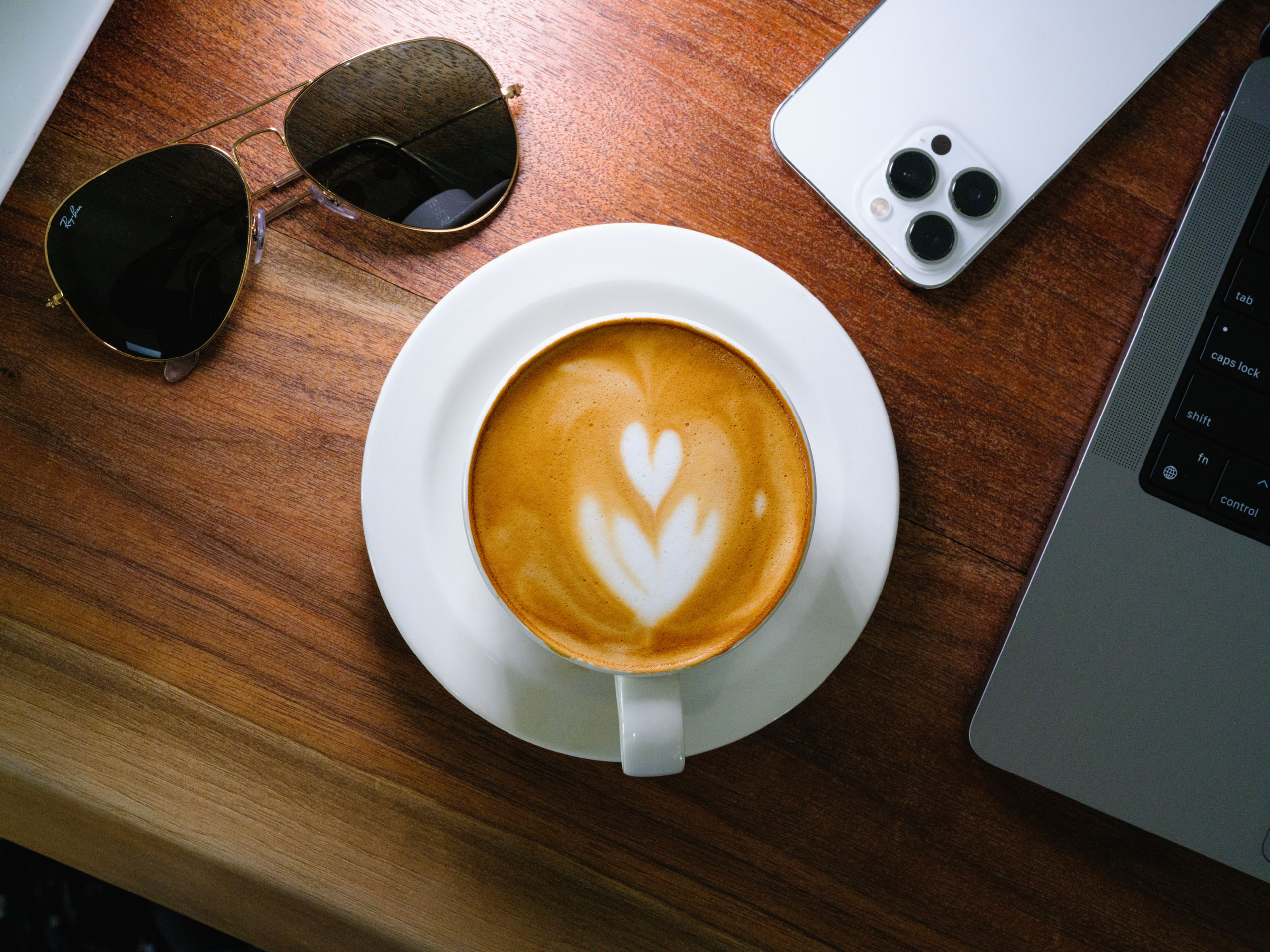 Coffee, sunglasses and phone flat lay, brand-content style.