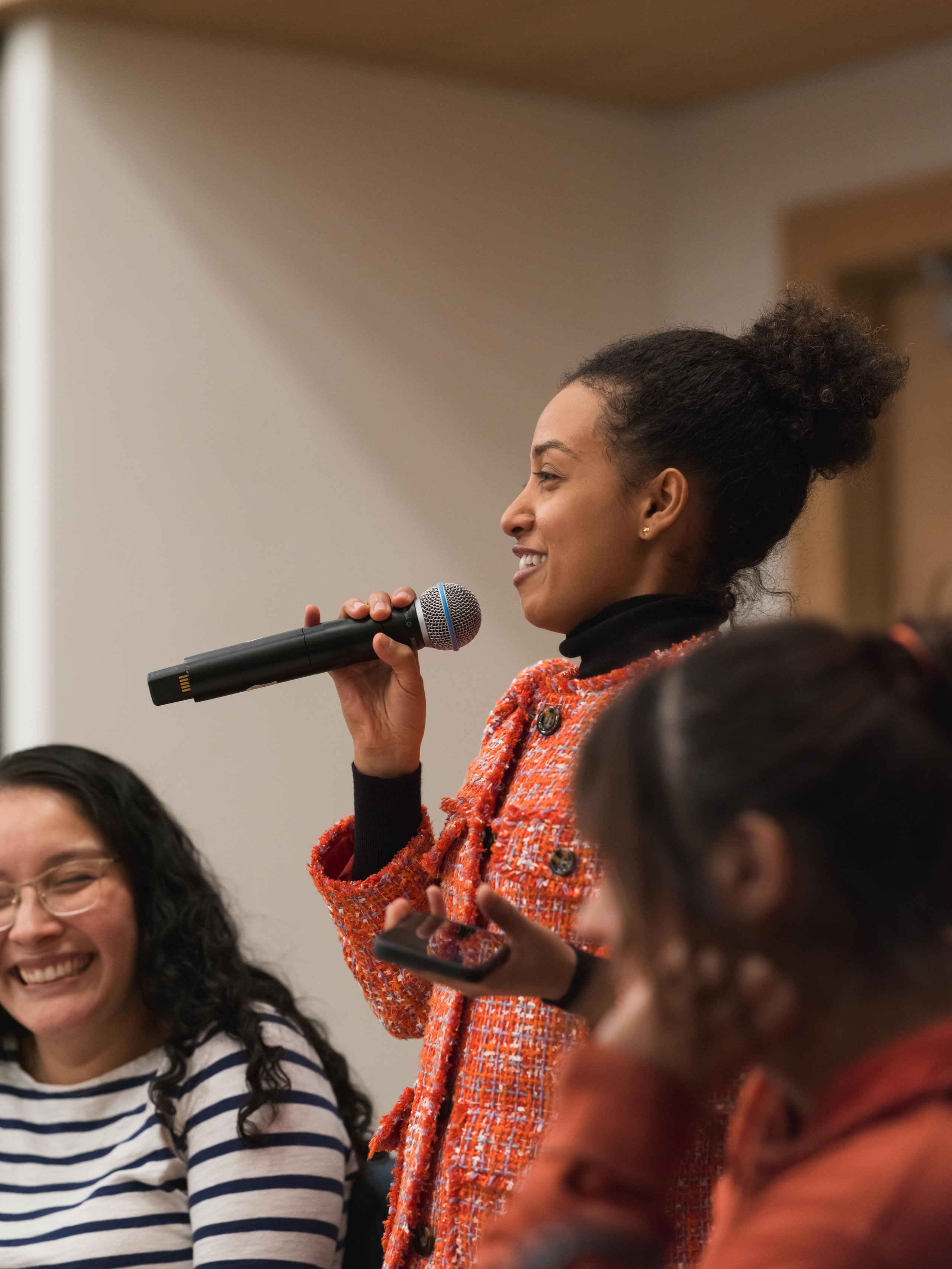 Young woman with the mic, color at a summit kickoff in Washington, DC.